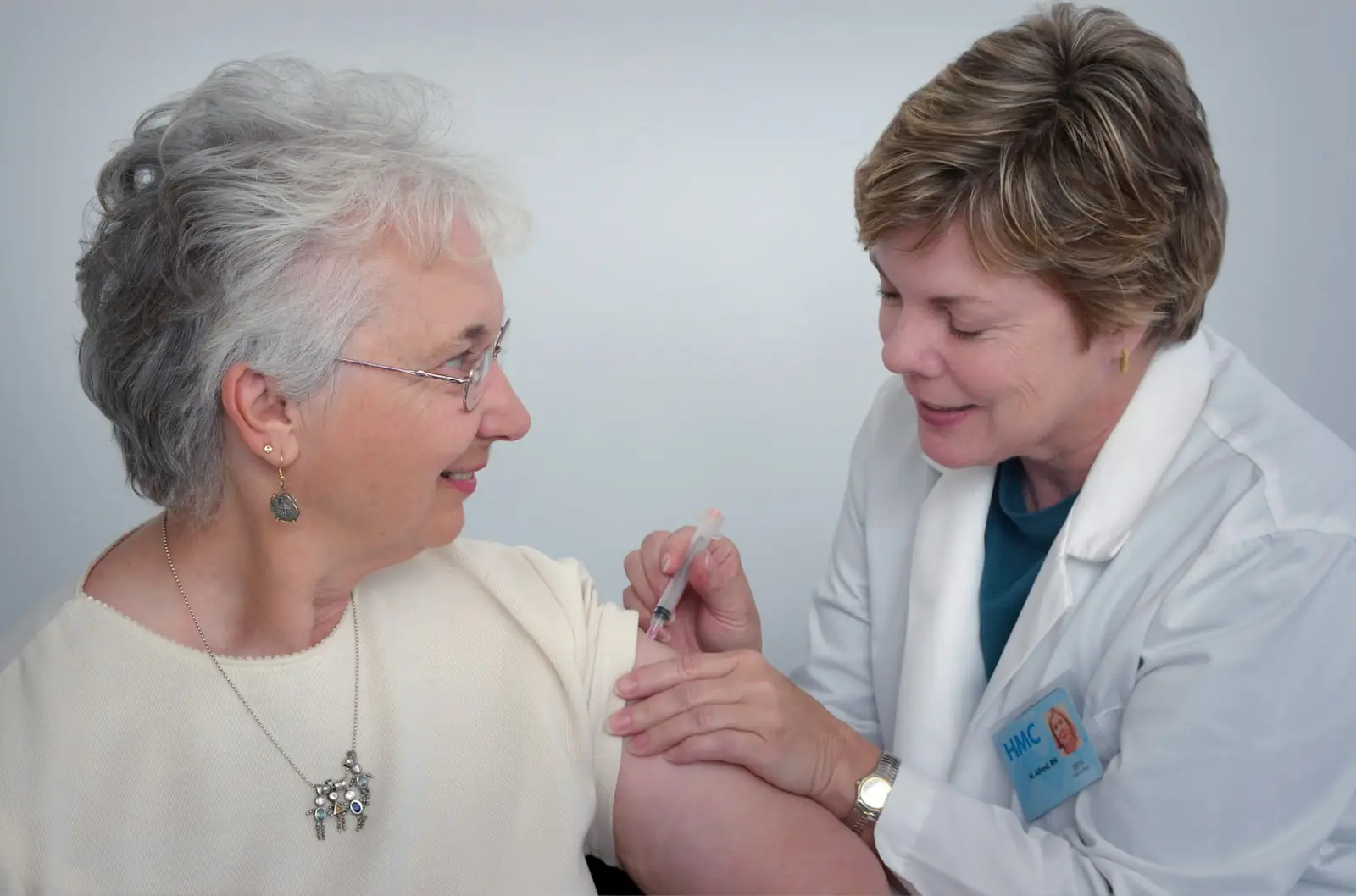 Nurse giving a vaccine to an older woman